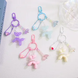 Detail of colorful balloon dog keychains with pearl collar and heart charms in four colors