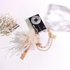 Elegant organza flower keychain with white feathers, pearls, and a gold heart charm