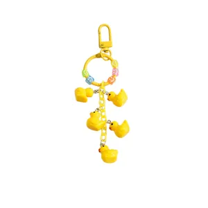 Cute yellow cartoon duck keychain with five charms and colorful letter beads on a ring