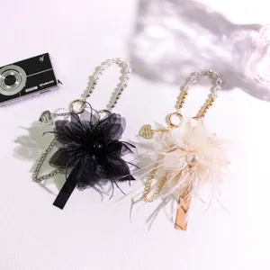 Elegant feather keychain with pearl beads and handmade heart charm in black and beige
