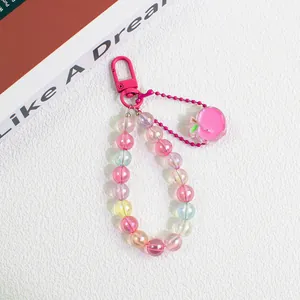 Detail of colorful gradient beads and pink acrylic apple pendant on a keychain