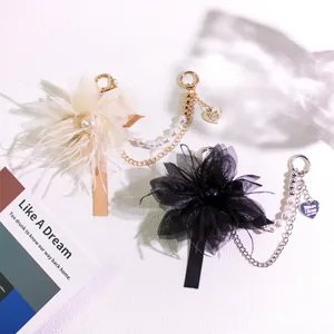 Close-up of elegant pearl flower charms with gold and silver hardware for bags and phones