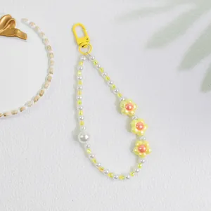 Detail of yellow flower phone charm with pearl beads and yellow lobster clasp