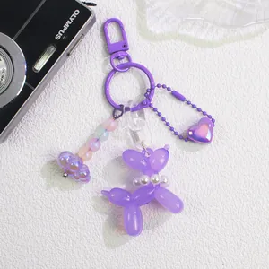 Detail of purple balloon dog keychain with heart pendant, colorful beads and pearl necklace