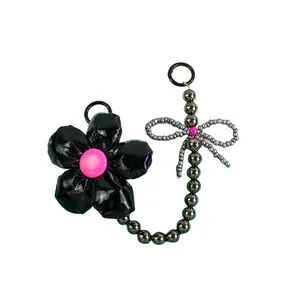 Exquisite handmade black floral bag charm with pink accents and beaded butterfly keychain