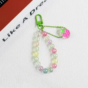 Detail of colorful acrylic beaded keychain with macaron beads and a pink strawberry charm