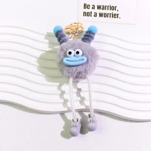 Close-up of potato-shaped fuzzy doll keychain with funny blue lips and metal ring