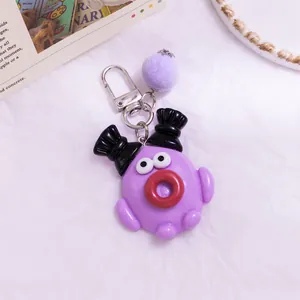 Détail d'un joli porte-clés dessin animé violet avec lèvres saucisses et pompon doux