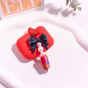Pendentif nœud iridescent et perles sur une coque en silicone rouge sur céramique