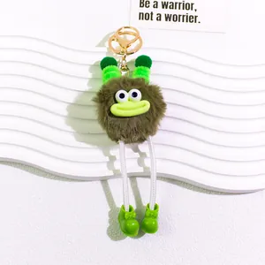 Detail of creative plush monster keychain with brown fur and green boots on white waves