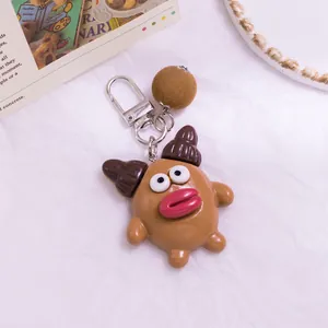 Vue détaillée d'un porte-clés monstre marron avec lèvres rouges et pompon en peluche