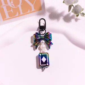 Vue détaillée du pendentif nœud iridescent avec perles blanches et breloque carreau