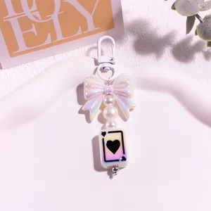 Détail du nœud nacré et du pendentif carte de poker cœur sur un porte-clés de style doux