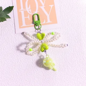 Detail of green beaded heart keychain with bow and lollipop charm on a lovely card