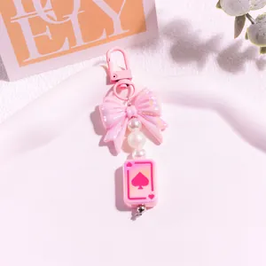 Détail du porte-clés nœud rose avec breloque carte à jouer et perles d'imitation