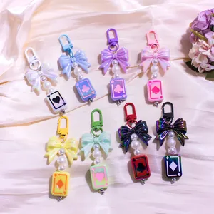 Porte-clés avec nuds en acrylique et breloques de cartes à jouer sur tissu en soie