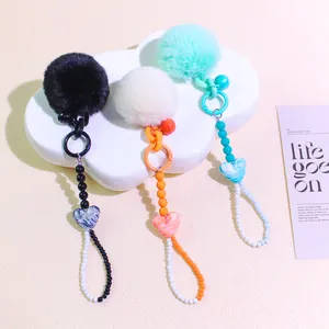 Detailed view of colorful plush pompom charms with beaded chains and heart resin pendants