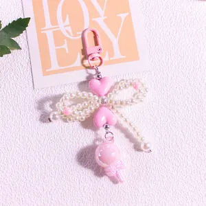 Close-up of heart lollipop keychain with pearl bow and pink lobster clasp detail