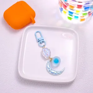 Close-up of cute cartoon cloud and pearlescent moon keychain with blue D-ring clasp