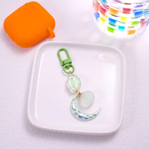 Detailed view of cloud and moon keychain with green metal clasp and floral crescent moon charm