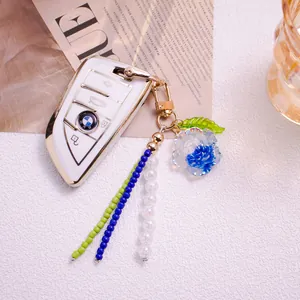 Custodia per chiavi BMW bianca con elegante ciondolo floreale di camelia perlata