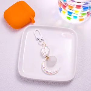 Detail of cartoon cloud and moon keychain with laser flower texture and white clasp