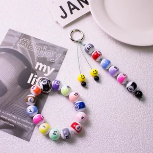 Detailansicht von buntem Billardkugel-Armband und Schlüsselanhänger mit Smiley-Anhängern