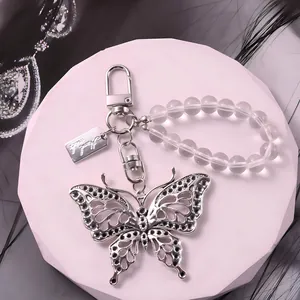 Detailweergave van zilveren vlinderhanger met matte kralen en elegante kreeftsluiting
