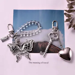 Elegante vlinder en hartvormige metalen hangers met kralenketting op decoratieve basis