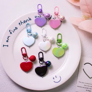 Elegant heart keychain set in seven colors displayed on a white tray with floral decor
