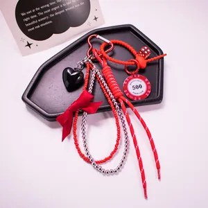 Red and black poker chip heart keychain with woven rope on a coffin tray for bags