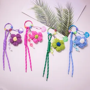 Set of four colorful handmade crochet flower charms with beads and heart tag on white background