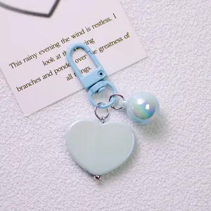 Detail of light blue heart keychain with iridescent bead and matching lobster clasp accessory