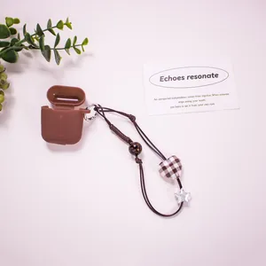 Brown silicone AirPods case with plaid heart charm and star woven lanyard decoration