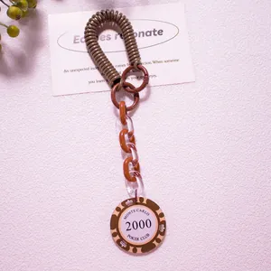 Macro shot of poker chip keychain with brown spring coil and acrylic chain links