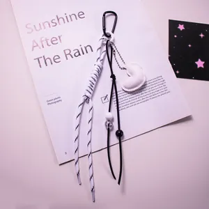 Détail d'un porte-clés cœur en cuir créatif avec corde tissée et clip en métal noir sur papier