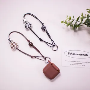 Checkered heart and star braided phone charms with a brown silicone earbud case