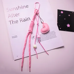 Détail du pendentif cœur en cuir rose avec corde tressée et perles sur un bijou de sac