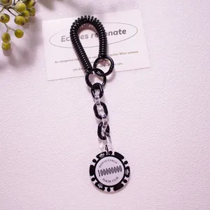 Detail of a black spiral cord keychain with a Monte Carlo poker chip acrylic pendant