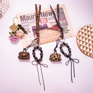 Close-up of leopard print mini coin purse keychain with beads and ribbon detail