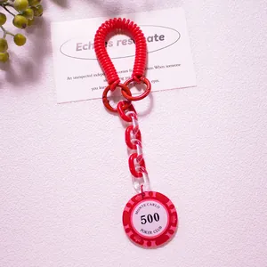 Macro view of red poker chip keychain with spring coil and acrylic chain links
