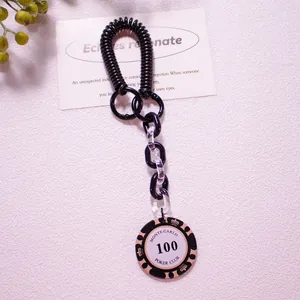 Macro view of vintage poker chip keychain with black spiral cord and acrylic chain links