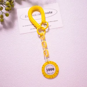 Detailed view of yellow spring keychain with Monte Carlo Poker chip and acrylic chain