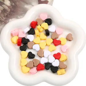 Vue détaillée de perles en acrylique colorées en forme de cœur pour bijoux DIY