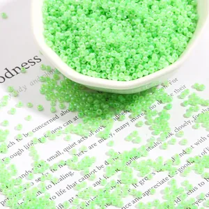 Light green glass seed beads for DIY jewelry making in a decorative white tray