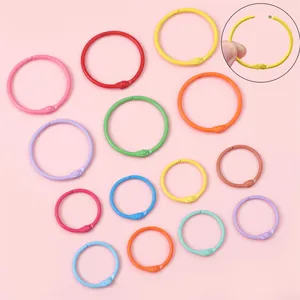 Anillos de metal de colores macarrón en varios tamaños mostrando el mecanismo de apertura