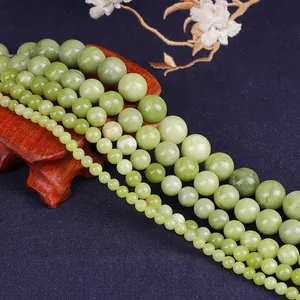 Macro view of green jade beads in various sizes on dark silk fabric background