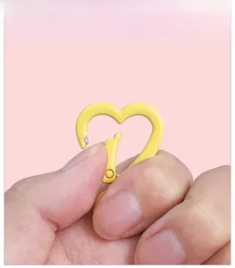 Macro shot of yellow heart-shaped alloy spring clasp with smooth painted finish