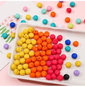 Vue détaillée de perles en acrylique colorées sur plateau blanc pour bijoux artisanaux