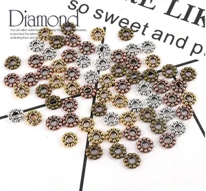 Detailed macro view of vintage zinc alloy flower spacer beads in four antique metallic colors
